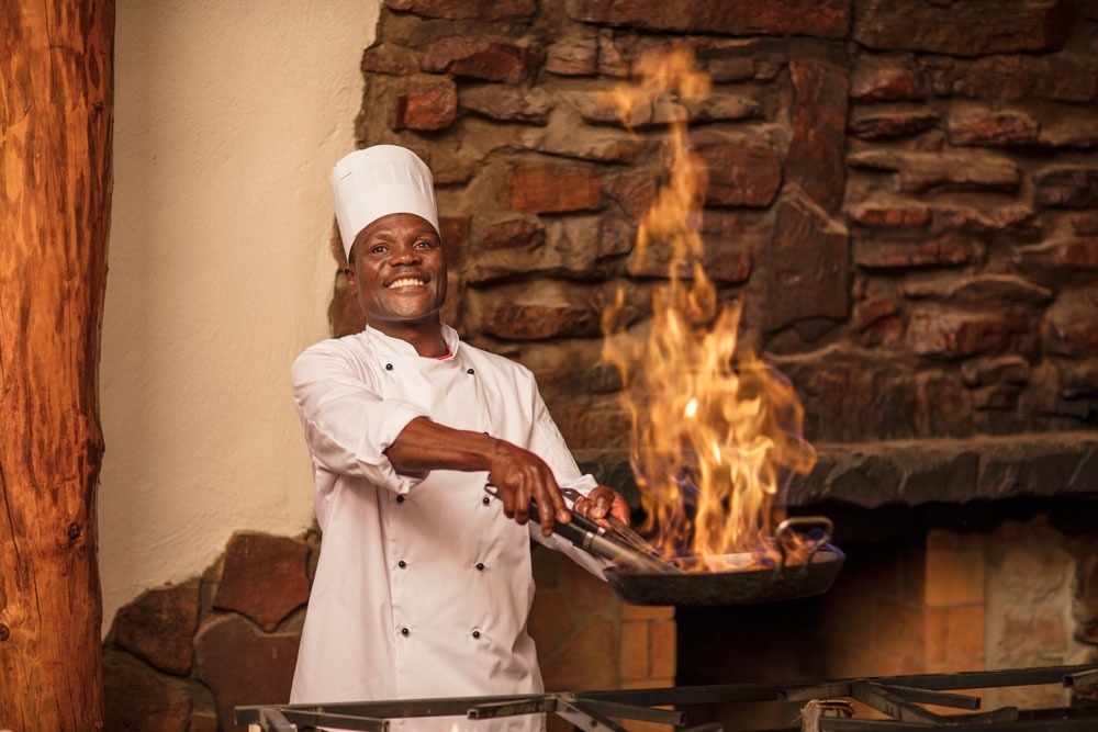 Aquila's restaurant: image showcasing trained chef preparing traditional African cuisine for Aquila's buffet-style restaurant menu