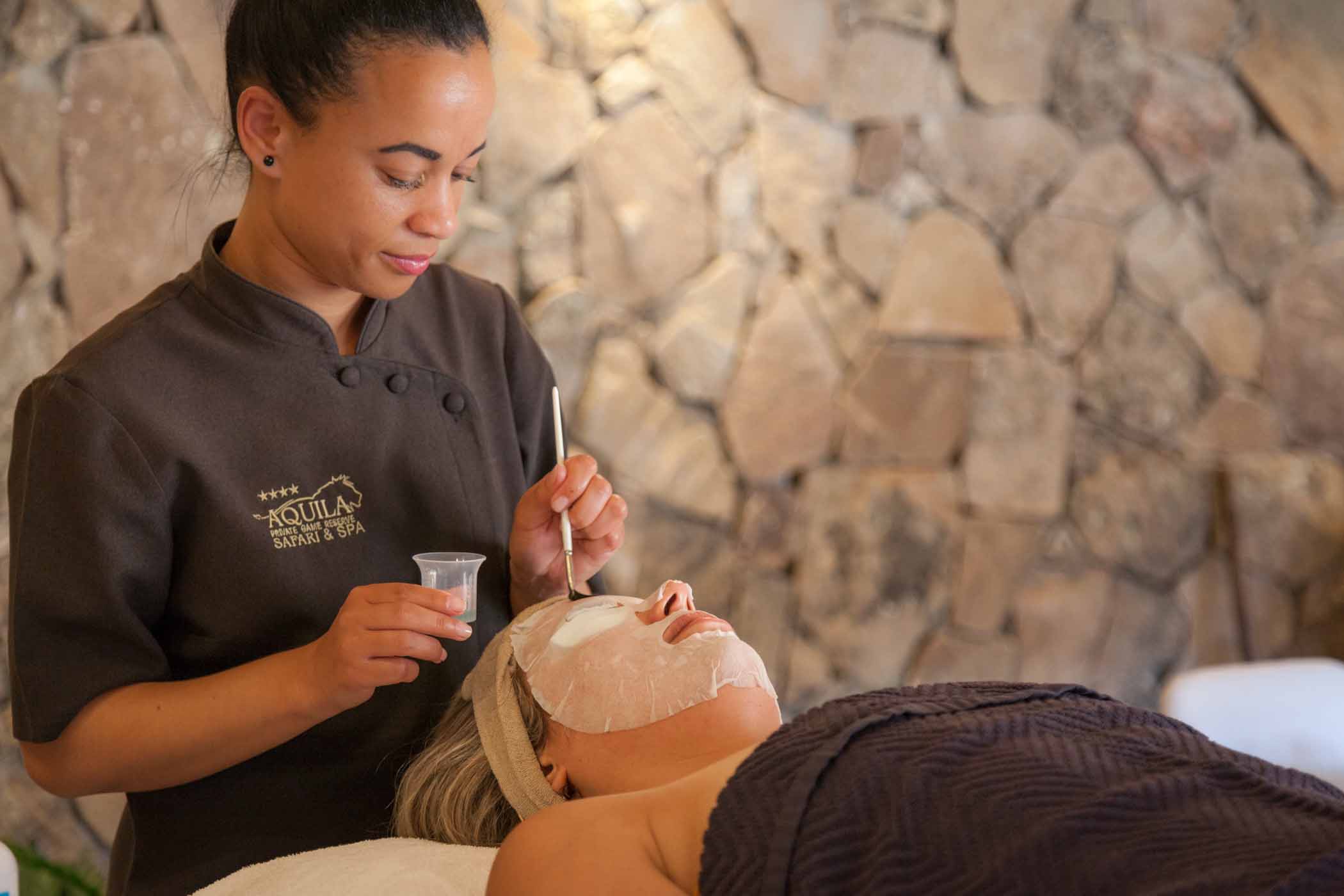 Tranquila Spa showing a woman lying on a spa table whilst experiencing a rejuvenating facial cleansing treatment.