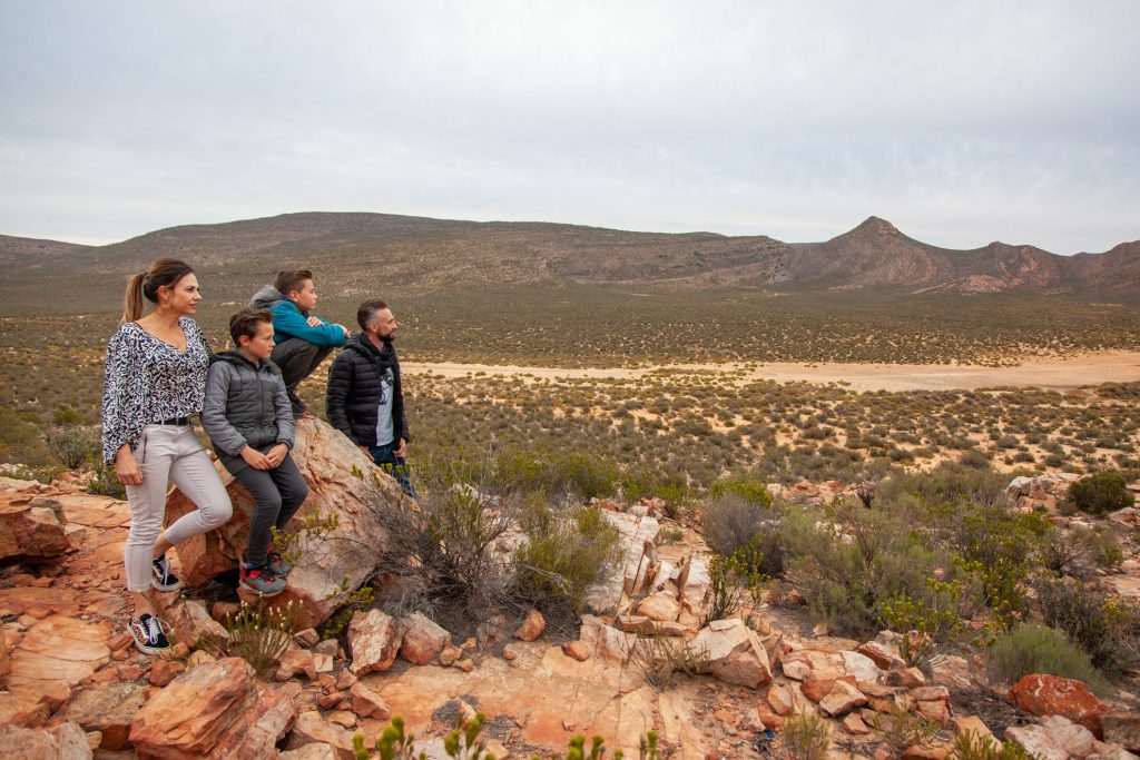 Featured image for Aquila news: Family of four overlooking the Karoo landscape where Aquila Game Reserve and Spa is situated